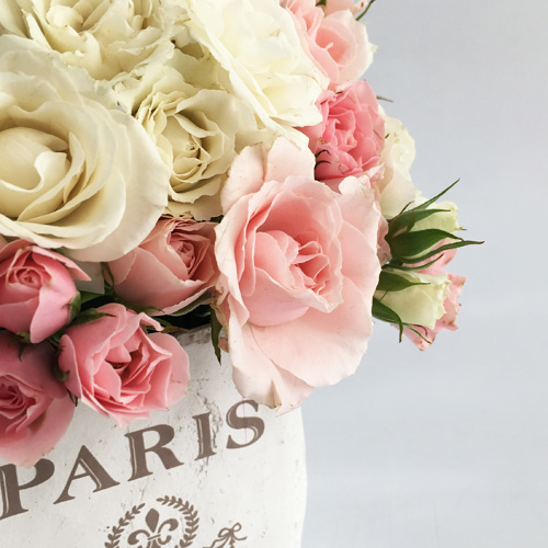 Arreglo floral de mini rosas de tonos pastel en base vintage